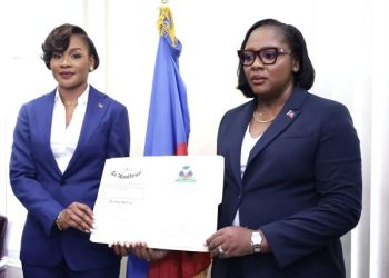 À à gauche la nouvelle Directrice Générale Lovely François, à droite la ministre Sandra Paulemon tenant ensemble l'empliation