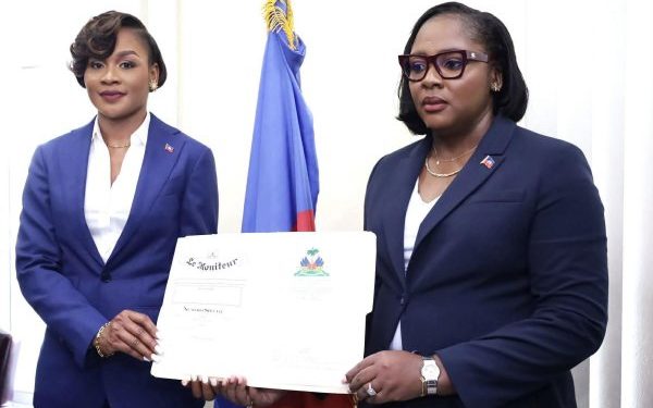 À à gauche la nouvelle Directrice Générale Lovely François, à droite la ministre Sandra Paulemon tenant ensemble l'empliation